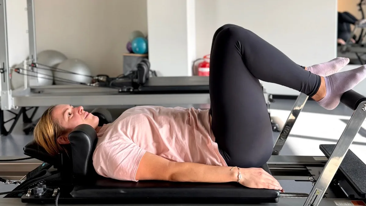 Лежане по гръб на реформъра със свити колене, студио Reform Pilates, София